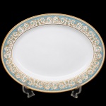 NORITAKE, Nagoya - Japão(Fundada em 1904 pelos irmãos Ichizaemon e Toyo Morimura). Exuberante travessa japonesa em porcelana da década de 1960/70, padrão POLONAISE (2045); Formato oval, raso, de centro ligeiramente rebaixado. Aba profusamente ornamentada por composição vegetalista, composta por rinceau, volutas, ramos, folhas e flores dispostas em repetição, sobre cartela de tonalidade azul ciano, seguindo repertório derivado de padrões europeus, estilo neoclássico e revivalista; contornos e elementos internos definidos por generosa aplicação de filetes à ouro, incluindo a borda e o centro. Marca da manufatura no verso. Medidas: Comprimento: 29,5 x Largura: 22,5 cm.