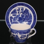 Belíssima xícara para chá inglesa executada em faiança japonesa. Esmaltagem na cor branca, bojo oval com alça lateral em voluta, dotado de rica decoração de tonalidade azul cobalto, padrão willow, aplicada por transferência, composta por paisagem fluvial contendo embarcação, personagens, ponte, pássaros, árvores e pagodes, padrão decorativo replicado no pires. Apresenta manchas do tempo e craquelado característico do envelhecimento do material. Marca da manufatura no verso. Pires adaptado de manufatura inglesa, vide fotos. Medidas: Xícara: Altura: 5 x Comprimento: 8,5 x Largura: 6 cm; Pires: Diâmetro: 10,7 cm.