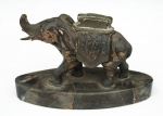 Isqueiro de coleção inserido em escultura animalista executado em metal prateado, representando figura de elefante, base oblonga em mármore(ou ônix). Apresenta desgaste no banho de prata, marcas de uso e sinais de oxidação no isqueiro. Isqueiro não está funcionando. Apresenta pequena quebradura na ponta da tromba. Medidas: Altura: 10 x Comprimento: 15,5 x Largura: 5 cm.