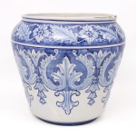 Grande cachepot em faiança portuguesa, de formato bojudo, decorado em esmaltação azul e branca com motivos vegetalistas estilizados em reservas contínuas. Produção da fábrica Cerâmica de Coimbra, Portugal, conforme marca na base. Apresenta craquelê de esmalte e quebradura colada na borda, vide foto. Medidas: Alt.: 30,5 x Diam.: 32 cm.