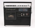 Rádio gravador AIKO, modelo ATPR-404, fabricação japonesa da década de 1980., aparelho portátil com receptor multibanda FM, MW, SW1 e SW2, gravador e reprodutor de fitas cassete, gabinete em material sintético com alça superior articulada, painel frontal com visor de frequências, comandos mecânicos superiores, controle de volume e tonalidade, indicador analógico de nível de gravação e sistema automatic stop. Não foi testado, sem garantias de funcionamento, estado conforme fotografias. Medidas: Alt.: 24 x Comp.: 32 x Larg.: 8,5 cm.