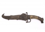 Sabre de inspiração oriental, lâmina curva em aço com gravação decorativa figurando cena de caça, empunhadura metálica em forma de cabeça zoomórfica, guarda vazada com terminais volutados e bainha metálica ornamentada em relevo com representações animalísticas. Medida: Comp.: 35,5 cm.