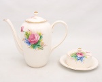 Conjunto em faiança brasileira marca RR, São Paulo, composto por um(01) bule para café e uma(01) manteigueira, corpos de contorno bojudo, decoração floral policromada aplicada sobre fundo branco e filetes dourados nas bordas e arremates. Bule apresenta craquelado e leves manchas do tempo, manteigueira apresenta fio interno e bicados na borda. Medidas: Bule: Alt. 21,5 x Comp.: 25,5 x Larg.: 12 cm. Manteigueira: Alt.: 7 x Diam.: 16 cm.