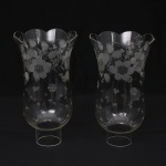 Duas(02) tulipas para lustre em meio cristal, translúcido e incolor, talhado com flores, folhagens e estrelas, borda recortada em arcos, bocal cilíndrico. Medidas: Alt.: 18 x Diam.: 10 cm.