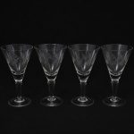 CRISTAL HERING. Elegante conjunto de taças para vinho tinto em cristal, diáfano e incolor; bojo obcônico talhado com folhagens estilizadas dispostas em faixas horizontal, fuste tubular, de topo facetado, sobre base circular. Composto de quatro(04) unidades. Medidas: Alt.: 15,5 x Diam.: 8,5 cm.