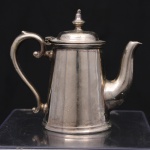 Bule miniaturizado em metal prateado da manufatura inglesa Mappin & Webb, corpo troncocônico, bico vertedor recurvo, alça letral em voluta e tampa articulada encimada por pináculo. Marcado na base Mappin & Webb, Princes Plate, London & Sheffield, modelo W11105. Medidas: Alt.: 10 x Comp.: 12 x Larg.: 6 cm.