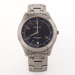 Relógio de pulso masculino Orient, executado em aço inoxidável, caixa circular com mostrador em tonalidade azul, algarismos arábicos aplicados, calendário na posição das seis horas e pulseira metálica articulada. Mostrador inscrito Water Resist 50 m. Tampa posterior marcada All Stainless Steel  Water Resist 50m. Movimento japonês.  Não está funcionando, apresenta desgastes e marcas de uso.Medidas: Diâmetro.: 36 mm.