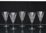 Elegante conjunto de taças de pé alto, para vinho, em cristal diáfano e incolor; bojo obcônico talhado com motivos florais e geométricos, composta por estrelas e painéis facetados, fuste tubular sobre base circular. Composto de cinco(05) unidades. Medidas: Alt.: 17 x Diam.: 9,5 cm.