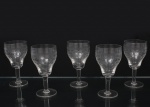 Conjunto de taças para vinho do Porto em meio cristal, diáfano e incolor; bojo campaniforme lavrado com padrão geométrico em repetição, fuste tubular sobre base circular. Composto de cinco(05) unidades. Medidas: Alt.: 13,5 x Diam.:  7 cm.