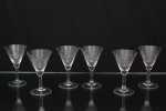 Conjunto de taças em cristal, diáfano e incolor, para serviço de vinho do Porto; bojo obcônico decorado com lapidação geométrica em padrão losangular e facetas entrecruzadas na porção inferior, fuste tubular sobre base circular. Composto de sete(07) unidades. Medidas: Alt.: 10 x Diam.: 6,5 cm.