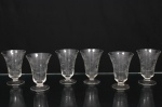Conjunto de taças para vinho do Porto em cristal translúcido, bojo campaniforme, haste curta e pé circular. talhado com motivos florais e folhagens entrelaçadas em composição contínua ao redor do bojo. Composto de seis(06) unidades. Medidas: Alt.: 10 x Diam.: 7 cm.