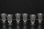 Conjunto de taças para vinho do Porto em cristal translúcido, bojo campaniforme, haste curta e pé circular. talhado com motivos florais e folhagens entrelaçadas em composição contínua ao redor do bojo. Composto de seis(06) unidades. Medidas: Alt.: 10 x Diam.: 7 cm.