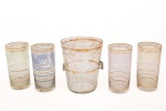 Conjunto da década de 1960/70 para refrescos em vidro, composto por um(01) balde para gelo com alças laterais aplicadas e quatro(04) copos altos em tonalidades suaves translúcidas, decorados com frisos horizontais dourados e gravação vegetalista estilizada. Apresenta desgastes, vide foto. Medidas balde: Alt.: 15,5 x Diam.: 13 cm.