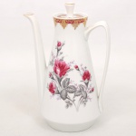 Porcelana Schmidt - Brasil(Fundada em 1945). Bule para café em porcelana nacional da década de 1960/70; esmaltação branca, decorado com reservas florais em policromia representando rosas e botões, complementadas por folhagens em tons de cinza, borda ornamentada com faixa de tonalidade bordô  e elementos rendilhados aplicados em douradura; bojo cônico, bico vertedor alongado, tampa removivel encimada por pega obcônica, alça lateral em grande arco estilizado. Marca da manufatura ao fundo. Medidas: Alt.: 20 x Comp.: 14 x Larg.: 10 cm.