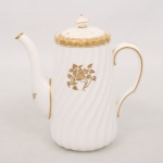 Minton, Staffordshire - Inglaterra. Excepcional bule para café em porcelana inglesa da década de 1950, padrão Gold Rose. Esmaltagem vítrea de tom branco perolado, realçado por profusa ornamentação com flores, faixas e filetes à ouro. Bojo aproximadamente cônico com alça lateral em voluta, ricamente modelado com frisos em espiral relevados na própria pasta, tampa encimada por pega com feitio de pião, bico vertedor curvado. Marca da manufatura ao fundo. Medidas: Alt.: 18,5 x Comp.: 17,5 x Larg.: 9,5 cm. Apresenta leves manchas do tempo.
