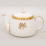 Minton, Staffordshire - Inglaterra. Excepcional bule para chá em porcelana inglesa da década de 1950, padrão Gold Rose. Esmaltagem vítrea de tom branco perolado, realçado por profusa ornamentação com flores, faixas e filetes à ouro. Bojo oblongo com alça lateral em voluta, ricamente modelado com frisos em espiral relevados na própria pasta, tampa encimada por pega com feitio de pião, bico vertedor curvado. Marca da manufatura ao fundo. Medidas: Alt.: 114 x Comp.: 13 x Larg.: 11,5 cm.