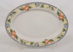 Travessa oval em porcelana branca, manufatura chinesa, com aba decorada por faixa contínua em policromia representando cachos de uvas, ameixas e pêssegos, emoldurada por cercadura geométrica. Marca no verso Fine Porcelain  Made in China. Medidas: Comp.: 36,5 x Larg.: 27 cm.