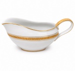 Porcellana Mauá, Mauá - SP(Fundada em 1937 por Fritz Erwin Schmidt / ativa até 1968). Elegante molheira navicular em porcelana nacional da década de 1950/60; esmaltagem vítrea na cor branca, bojo oblongo circundado por faixa com padrão de meandro grego entre frisos em douradura, ornato que se replica no contorno da borda e da alça lateral. Marca da manufatura no verso. Medida: Alt.: 9 x Comp.: 21 x Larg.: 10 cm.
