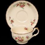 W.H. GRINDLEY, Staffordshire - Inglaterra(Fundada por William Harry Grindley em 1880). Xícara para chá em faiança inglesa da década de 1940/50, padrão "Creampetal"; esmaltagem de tom marfim, decoração floral policroma com reservas de rosas e flores campestres distribuídas pelo bojo e caveto, aplicada por transferência. Bordas recortadas com acabamento em douradura, repetido na asa lateral em voluta. Marca da manufatura no verso. Medidas: Xícara: Alt.: 5,5 x Comp. 11,5 x Larg.: 9 cm; Pires: Diam.: 14,5 cm.