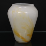 Vaso em vidro artístico opalino, de corpo bojudo afunilado para a base e boca circular ligeiramente reentrante, decorado com inclusões e nuances em tons de amarelo e âmbar obtidas durante a fusão do vidro. Medidas: Alt.: 22,5 x Diam.: 18,5 cm.