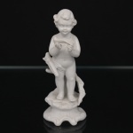 Escultura em porcelana de biscuit representando putto em pé junto a tronco estilizado, segurando ave nas mãos, sobre base moldada de contorno movimentado. Produção decorativa europeia, final do século XIX ou início do século XX. Marcada em relevo na base. Estado de conservação com desgastes, pequenas manchas, leves perdas e bicados localizados, notadamente na extremidade da ave e em pontos da superfície. Condição conforme fotografias. Medidas: Alt.: 13,5 x Diam.: 6 cm.