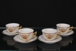 Porcelana Monte Alegre, São Caetano do Sul - SP. Conjunto de xícaras para café em porcelana nacional, bojo hemisférico e asa lateral vazada com modelagem angulada. Decoração em esmaltação branca com aplicações em douração brunida na borda e na asa. Reservas decorativas compostas por cestos florais com arranjos fitomórficos policromos em tons rubro, amarelo e dourado, executados em pintura esmaltada e realces em ouro. Superfície ornada por filetes e motivos curvilíneos esparsos em douração. Marca da manufatura ao fundo. Composto de quatro(04) unidades. Medidas: Xícara: Alt.: 4 Diam.: 7 cm. ;  Pires: Diam.: 10,5 cm.