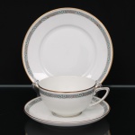 Trio para chá em porcelana alemã, manufatura Rosenthal, Alemanha (Selb-Bavaria), decoração em esmalte nas tonalidades verde e cinza formando faixa geométrica com motivos florais estilizados, realçada por filetes dourados nas bordas. Marca da manufatura no verso. Medidas: Xícara: Alt.: 5 x Comp.: 12 x Larg.: 9,5 cm. ; Pires: Diam.: 14,5 cm. ; Prato: Diam.: 17 cm.