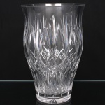 Vaso em espesso cristal incolor lapidado, translúcido e incolor, corpo de perfil ligeiramente bojudo e borda alargada. Decorado com lapidação geométrica composta por pontas de diamante, losangos e reservas reticuladas. Apresenta dois bicados na borda. Medidas: Alt.: x Diam.: