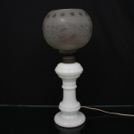 Luminária de mesa composto por coluna torneada em vidro opalino branco e cúpula esférica em vidro fosco gravado, decorada com motivos fitomorfos e janelas circulares na borda superior. Montagem com elementos metálicos e instalação elétrica adaptada. Medidas: Alt.: 45 x Diam.: 19 cm.
