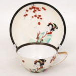 Xícara para chá em porcelana japonesa, bojo hemisférico com alça estilizada integrada. Decoração policromada representando figura feminina em trajes tradicionais japoneses, acompanhada por ramos de folhas estilizadas. Borda realçada por friso em tonalidade preta e contorno com filete dourado. Base marcada com inscrição Made in Japan. Medidas: Xícara: Alt.: 5 x Comp.: 12 x Larg.: 10 cm. ; Pires: Diam.: 15 cm.