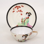 Xícara para chá em porcelana japonesa, bojo hemisférico com alça estilizada integrada. Decoração policromada representando figura feminina em trajes tradicionais japoneses, acompanhada por ramos de folhas estilizadas. Borda realçada por friso em tonalidade preta e contorno com filete dourado. Base marcada com inscrição Made in Japan. Medidas: Xícara: Alt.: 5 x Comp.: 12 x Larg.: 10 cm. ; Pires: Diam.: 15 cm.