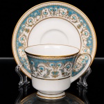 NORITAKE, Nagoya - Japão(Fundada em 1904 pelos irmãos Ichizaemon e Toyo Morimura). Exuberante chávena para chá em porcelana da década de 1960/70, padrão POLONAISE (2045); bojo obcônico assente sobre base circular, asa lateral curvada, esmaltagem vítrea na cor branca, profusamente ornamentada por composição vegetalista, composta por rinceau, volutas, ramos, folhas e flores dispostas em repetição, sobre cartela de tonalidade azul turquesa, realçados por rica aplicação de douração, seguindo repertório derivado de padrões europeus, estilo neoclássico e revivalista; bordas contornadas com generosa aplicação de filetes à ouro e faixa perolada pontilhada, padrão decorativo integralmente replicado no pires. Marca da manufatura no verso. Medidas: Chávena: Alt.: 7,5 x Comp.: 11 x Larg.: 9 cm; Pires: Diam.: 15 cm.