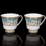NORITAKE, Nagoya - Japão(Fundada em 1904 pelos irmãos Ichizaemon e Toyo Morimura). Duas(02) chávenas para chá(sem pires) em porcelana da década de 1960/70, padrão POLONAISE (2045); bojo obcônico assente sobre base circular, asa lateral curvada, esmaltagem vítrea na cor branca, profusamente ornamentada por composição vegetalista, composta por rinceau, volutas, ramos, folhas e flores dispostas em repetição, sobre cartela de tonalidade azul turquesa, realçados por rica aplicação de douração, seguindo repertório derivado de padrões europeus, estilo neoclássico e revivalista; bordas contornadas com generosa aplicação de filetes à ouro e faixa perolada pontilhada. Marca da manufatura no verso. Medidas: Chávena: Alt.: 7,5 x Comp.: 11 x Larg.: 9 cm.