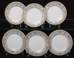 NORITAKE, Nagoya - Japão(Fundada em 1904 pelos irmãos Ichizaemon e Toyo Morimura). Exuberante conjunto de pratos rasos para pão em porcelana da década de 1960/70, padrão POLONAISE (2045); esmaltagem vítrea na cor branca, aba profusamente ornamentada por composição vegetalista, composta por rinceau, volutas, ramos, folhas e flores dispostas em repetição, sobre cartela de tonalidade azul ciano, seguindo repertório derivado de padrões europeus, estilo neoclássico e revivalista; borda e caldeira circundadas generosa aplicação de filetes à ouro. Marca da manufatura no verso. Composto de seis(06) unidades. Medida: Diam.: 16 cm.