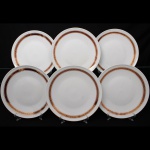 Porcelana, Steatita e Magnésia S/A, Campo Largo - PR(Fundada em 1954). Elegante conjunto de pratos rasos em porcelana nacional da década de 1960/70, esmaltagem vítrea na cor branca, orla decorada por faixa de tonalidade bordô, ornamentada por arabescos fitomorfos dourados em repetição, cercado por frisos em douradura. Composto de seis(06) unidades. Medida: Diam.: 25 cm.