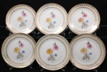 Porcelana Real, Mauá - SP(Fundada em 1943 por Fritz Erwin Schmidt). Elegante conjunto de pratos para sobremesa em porcelana nacional da década de 1950/60; esmaltagem vítrea na cor branca, orla circundada por faixa de acabamento nacarado, sobreposta por barrado contínuo de leques estilizados, guirlandas e frisos em douradura, centro dotado de bela composição botânica em estampagem policromada, predominando as tonalidades preta, rosa, azul e amarelo. Marca manufatura no verso. Composto de seis(06) unidades. Medida: Diam.: 19 cm.