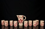 S.I.C. (Scuola Italiana Ceramica), Casale Monferrato - Itália. Elegante conjunto para refresco em majólica italiana da década de 1950/60; esmaltação vítrea de tonalidade creme, decorado com composição botânica manual em tom bordô; Composto de uma(01) jarra com bico vertedor pronunciado e alça lateral em arco, acompanhada de nove copos cilíndricos. Marca da manufatura ao fundo. Medida: Jarra: Alt. 21 x Comp.: 20 x Larg.: 11 cm; Copos: Alt.: 10 x Diam.: 7 cm.