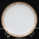 Porcelana Real, Mauá - SP(Fundada em 1943 por Fritz Erwin Schmidt). Prato de serviço em porcelana branca, de formato circular, com aba decorada por composição de volutas, flores, folhas e campânulas em policromia, interligadas por filetes dourados. Borda ornada por faixa contínua dourada com padrão geométrico gravado. Marca da manufatura no verso. Medida; Diam.: 28 cm.