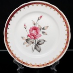 Prato de coleção em porcelana nacional da década de 1960/70; esmaltação branca, decorado com reserva floral em policromia representando rosas e botões, complementadas por folhagens em tons de cinza, borda ornamentada com faixa de tonalidade bordô e elementos rendilhados aplicados em douradura. Marca da manufatura no verso. Medidas: Diam.: 26,5 cm.