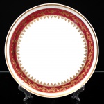 Porcelana Schmidt - Brasil(Fundada em 1945). Belíssimo bandeja circular em porcelana nacional da década de 1960/70;  esmaltagem vítrea na cor branca, decorado com faixas de tom rubi e ornamentação em douradura aplicada, formando cercaduras de arabescos, elementos fitomorfos e rendilhados estilizados; borda contornadas por filete à ouro. Marca da manufatura no verso. Medida: Diam.: