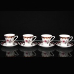 Porcelana Schmidt - Brasil(Fundada em 1945). Xícaras para café em porcelana nacional da década de 1960/70; esmaltação branca,  decorado com reservas florais em policromia representando rosas e botões, complementadas por folhagens em tons de cinza, borda ornamentada com faixa de tonalidade magenta e elementos rendilhados aplicados em douradura; bojo obcônico sobre base circular, alça lateral estilizada. Marca da manufatura ao fundo. Medidas: Xícara: Alt.:6 x Comp.: 8,5 x Larg.: 6,5 cm; Pires: Diam.: 11 cm.