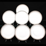Porcelana Renner, Porto Alegre - RS(Fundada em 1937). Conjunto de pratos para sobremesa em porcelana nacional da década de 1960/70; esmaltação na cor branca, borda ornada por cercadura em meandro contínuo, de tonalidade cinza, e sucessão de quadrados duplos em douração aplicada. Marca da manufatura no verso. Composto de sete(07) unidades. Medida: Diam.: 17,5 cm.