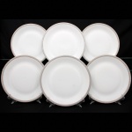 Porcelana Renner, Porto Alegre - RS(Fundada em 1937). Conjunto de pratos rasos em porcelana nacional da década de 1960/70; esmaltação na cor branca, borda ornada por cercadura em meandro contínuo, de tonalidade cinza, e sucessão de quadrados duplos em douração aplicada. Marca da manufatura no verso. Composto de seis(06) unidades. Medida: Diam.: 25 cm.