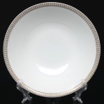 Porcelana Renner, Porto Alegre - RS(Fundada em 1937). Bowl em porcelana nacional da década de 1960/70; esmaltação na cor branca, formato hemisférico, borda ornada por cercadura em meandro contínuo, de tonalidade cinza, e sucessão de quadrados duplos em douração aplicada. Marca da manufatura no verso. Medidas: Alt.: 5,5  x Diam.: 21,5 cm.