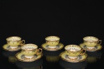 Conjunto de quatro(04) xícaras para café em porcelana nacional, corpo na tonalidade amarelo decorado com reservas centrais apresentando cenas galantes de inspiração clássica, cercadas por arabescos e frisos vegetalistas em douração. Marca da manufatura no verso. Medidas: Xícara: Alt.: 4 x Comp.: 8,5 x Larg.: 7 cm. ; Pires: Diam.: 11 cm.