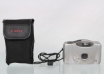 Câmera fotográfica analógica compacta Canon Prima BF-9s Date, corpo em acabamento prateado, equipada com lente fixa Canon Lens 32 mm, visor óptico e flash incorporado, com sistema de impressão de data, acompanhada de estojo de transporte Canon em material sintético. Não foi testada, sem garantias de funcionamento. Medidas: Alt.: 7,5 x Comp.: 12,5 x Larg.: 5 cm.