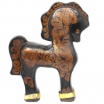 Escultura de cavalo em madeira entalhada e policromada, com decoração floral estilizada em dourado sobre fundo preto, inspirada na tradição artesanal russa de Khokhloma. Peça de caráter decorativo, apresentando crina, cauda e arreios estilizados integrados ao entalhe, com aplicações metálicas douradas nos cascos. Medidas: Alt.: 23,5 x Comp.: 20 x Larg.: 6,5 cm.