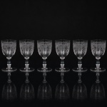 Belíssimo conjunto de taças francesas em cristal, do início do século XX, para serviço de vinho branco; bojo oval ricamente gravado com composição de influência neoclássica, composta por faixa superior em meandro grego delimitado por filetes paralelos, reservas cordiformes terminadas em volutas, arabescos e elementos vegetalistas; fuste balaústre, seguido de anel intermediário, sobre base circular. Composto seis(06) unidades. Medidas: Alt.: 15,5 x Diam.: 8 cm.