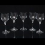 Conjunto de cinco(05) taças para vinho em cristal incolor, bojo oval, haste delgada com anéis aplicados junto ao cálice e pé circular. Medidas: Alt.: 16  x Diam.: 6,5 cm.