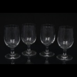 Conjunto de cinco(05) taças para vinho cristal incolor, com bojo hemisférico sobre haste delgada e pé circular, decoradas por faixa gravada em reserva com motivos de volutas e cartelas estilizadas de inspiração neoclássica. Medidas: Alt.: 14 x Diam.: 8,5 cm.